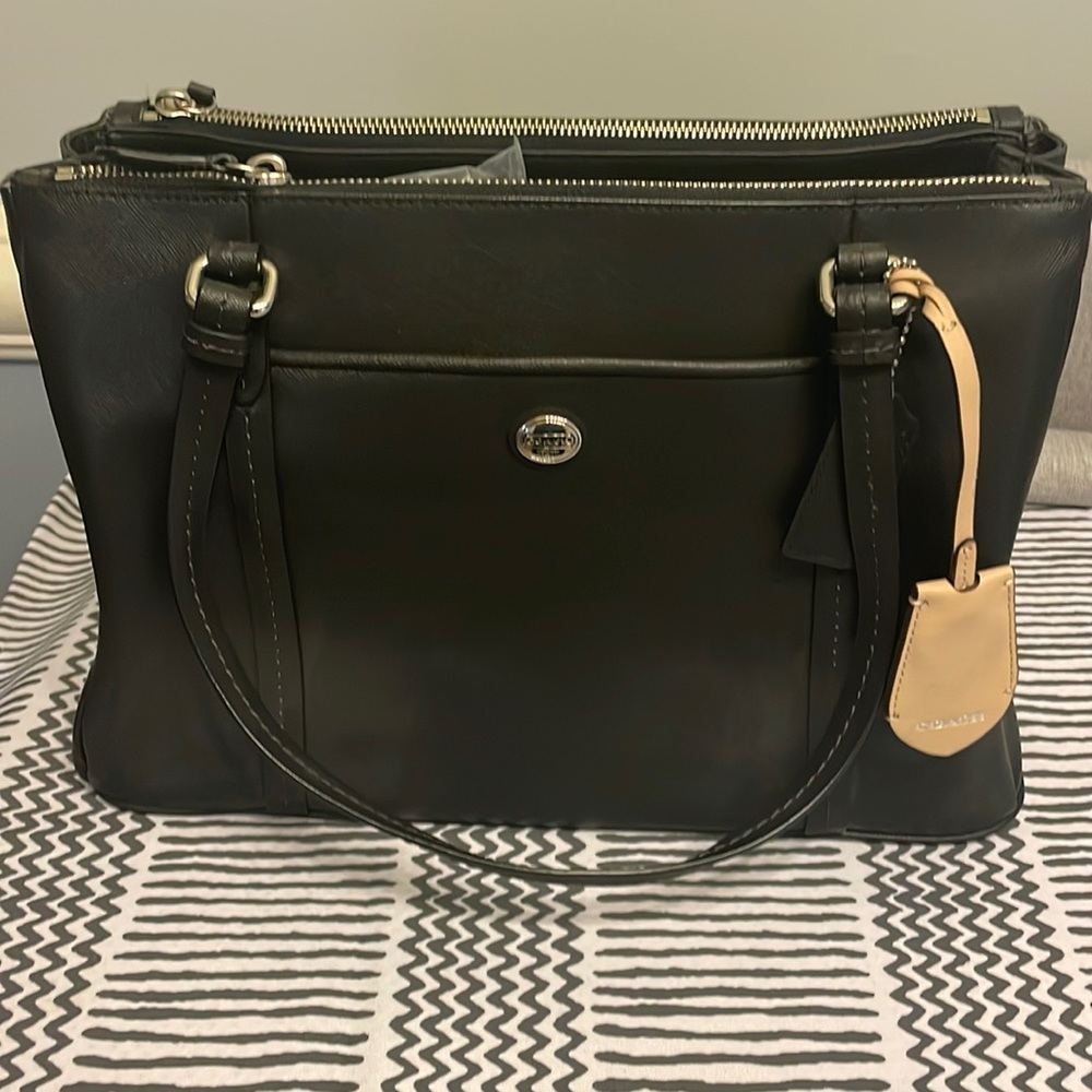 Coach black leather bag with a zipper pouch on each side. Lots of pockets